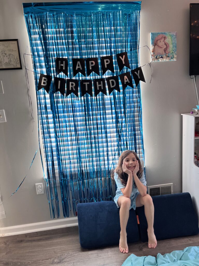 Birthday girl under a birthday banner