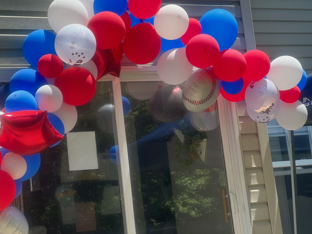 red white and blue baseball balloon arch