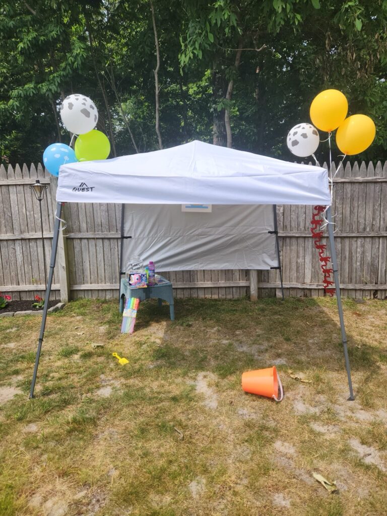 small party tent with balloons and bubble station