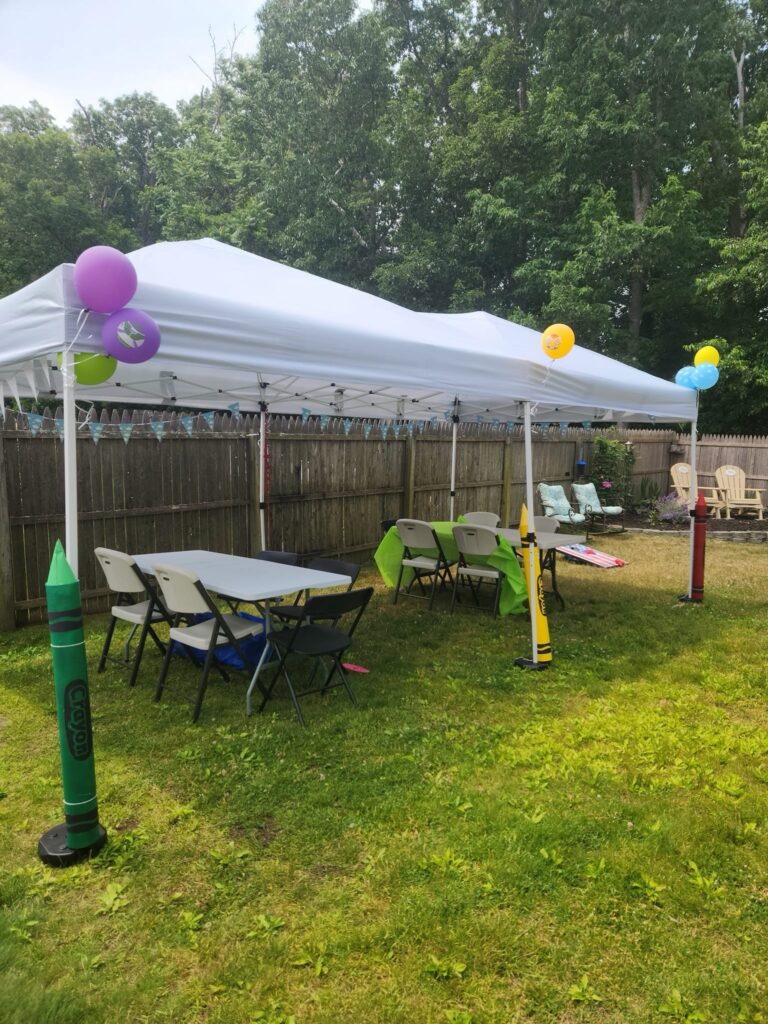 Party tent with balloons and over sized crayons