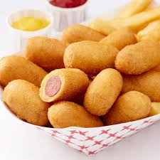 Mini corn dogs in red check paper baskets for a carnival party menu.