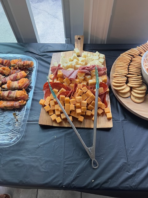 Charcuterie board at a Bourbon & BBQ 40th birthday party with cubed cheddar and mozzarella cheese, salami, pepperoni, and crackers on the side.