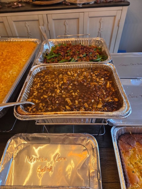 Buffet trays of baked beans with onions and green beans topped with crispy bacon, served at a Bourbon & BBQ 40th birthday party.