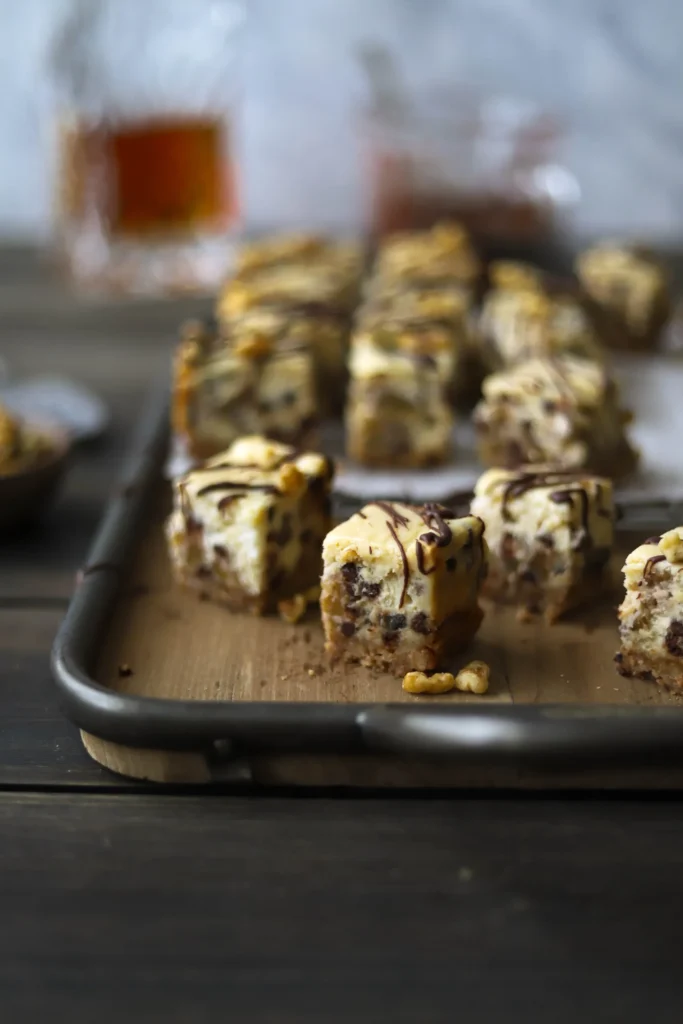 Bourbon chocolate chip cheesecake bites drizzled with chocolate, served as mini desserts at a Bourbon & BBQ 40th birthday party.