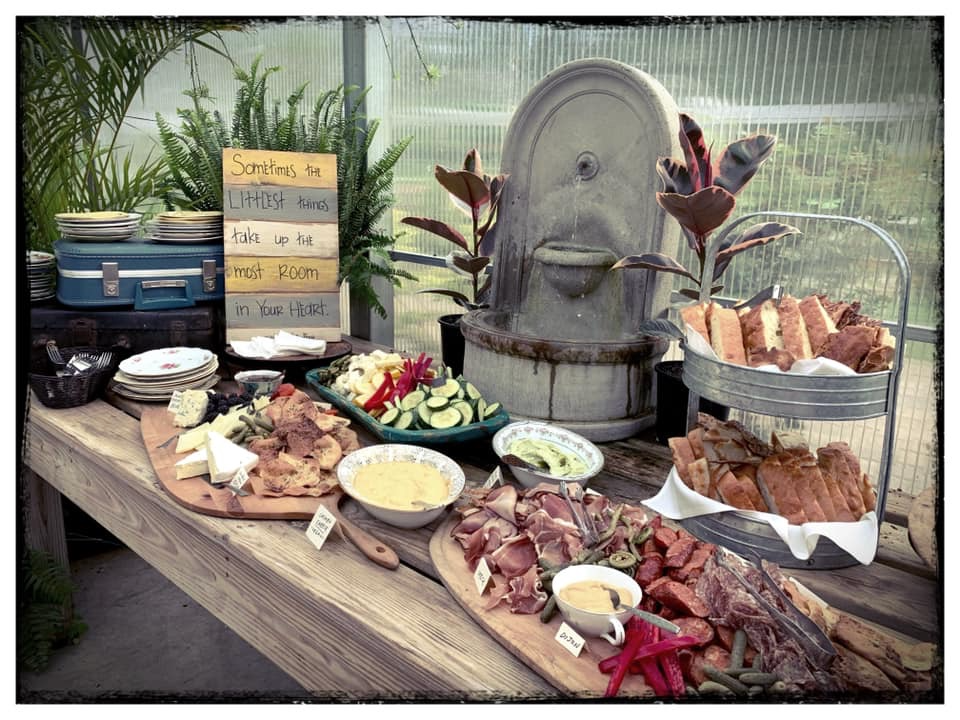 Garden party grazing table with charcuterie, fresh vegetables, dips, and rustic decor at a vintage Winnie the Pooh baby sprinkle