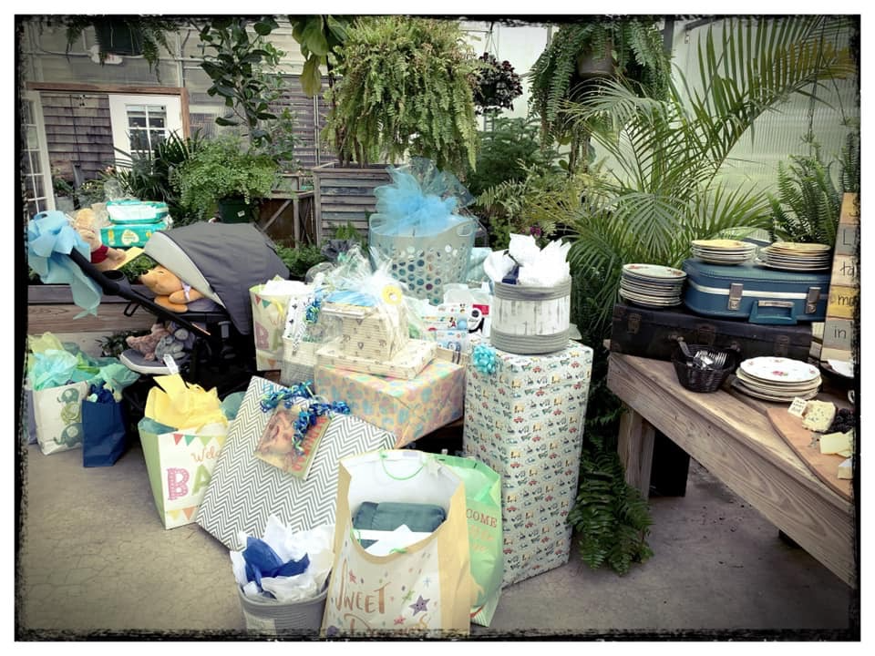 Baby gifts and decor displayed inside a greenhouse during a vintage Winnie the Pooh baby sprinkle