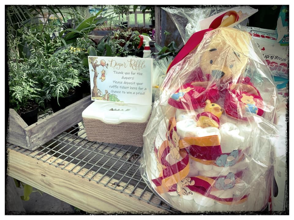 Winnie the Pooh themed diaper raffle station and baby shower prize basket at a vintage baby sprinkle